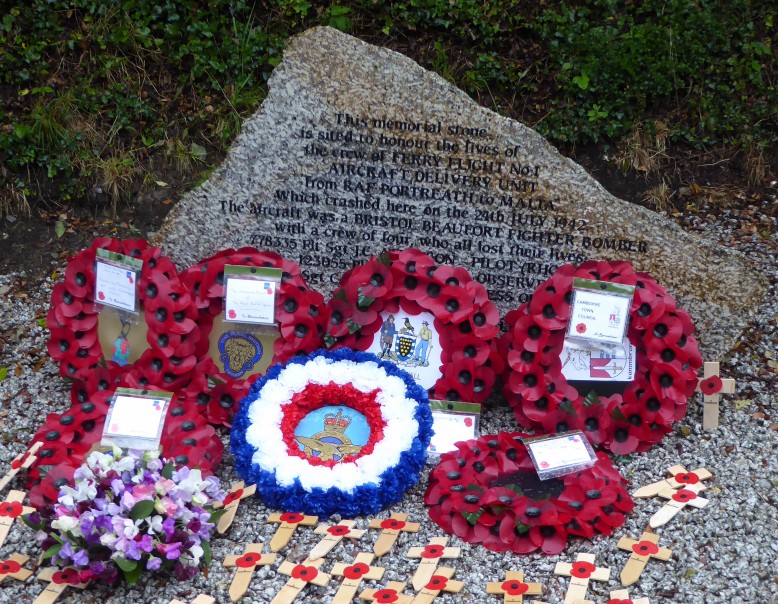 The memorial stone with wreaths at its foot.